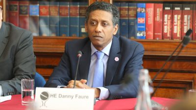 Bild på Seychellernas president Danny Faure. Han sitter i en talarstol och har en mikrofon framför sig.