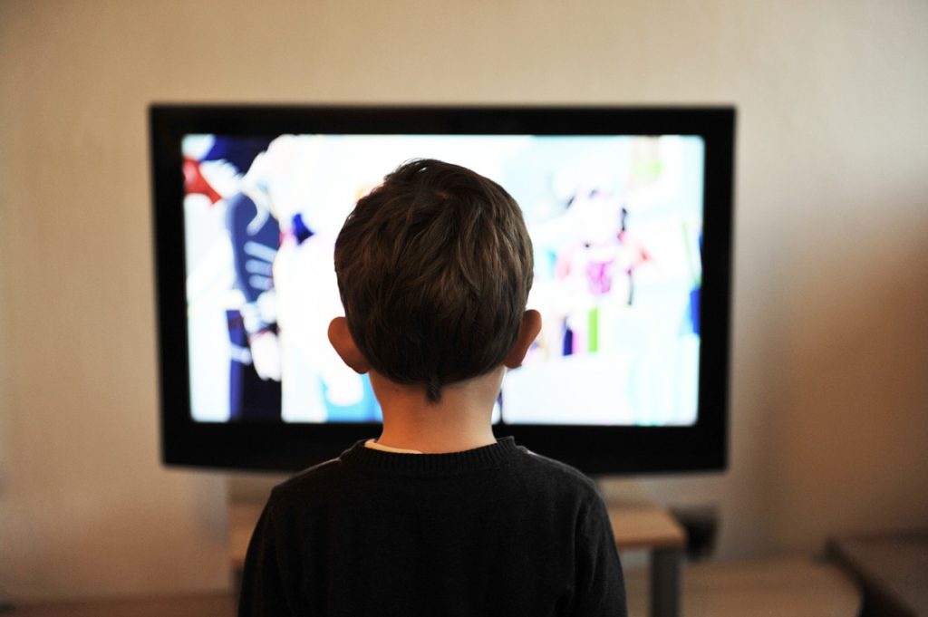 Ett barn som kollar på en tv-skärm